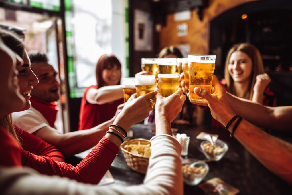 people talking and toasting in a pub with the beers